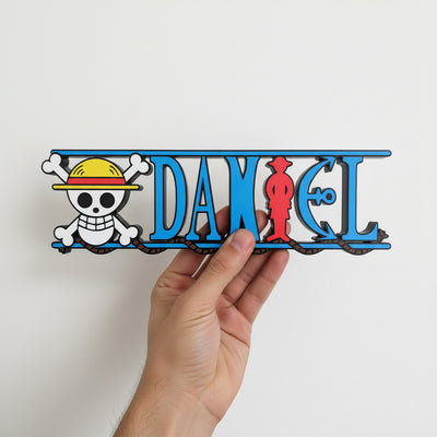 Hand holding a personalized one piece nameplate with the pirate crew jolly roger