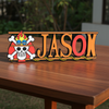 Personalized one piece nameplate with the Ace jolly roger on a wooden table