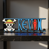 Personalized one piece nameplate with the pirate crew jolly roger on a shelf