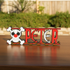 Personalized one piece nameplate with the Buggy jolly roger on a wooden table